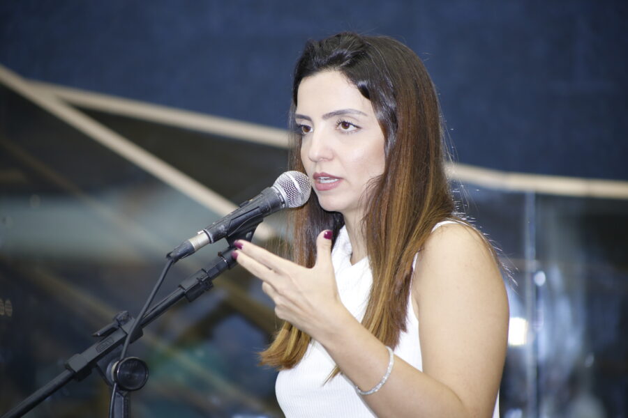 Vereador Marcela Trópia discursando em Plenário vestindo regata branca